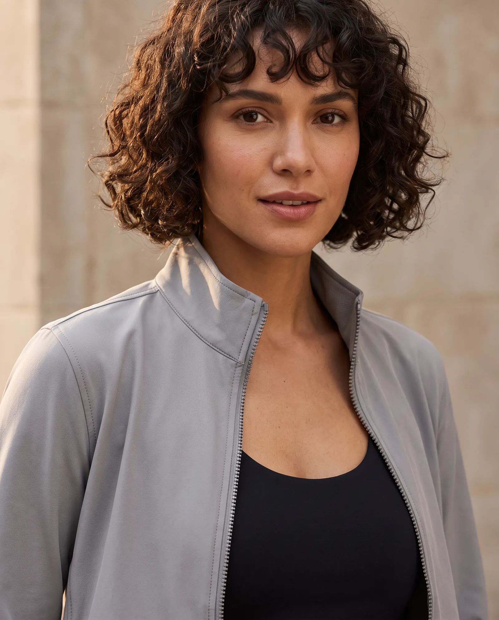 Close portrait of a woman in the light grey Zip Jacket, the front zip and clean chest in focus