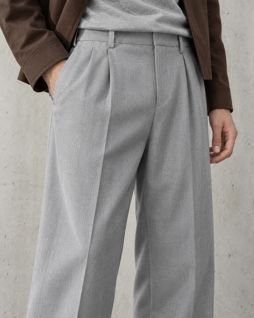Close-up of the light grey Pleated Trouser, the front pleats falling straight